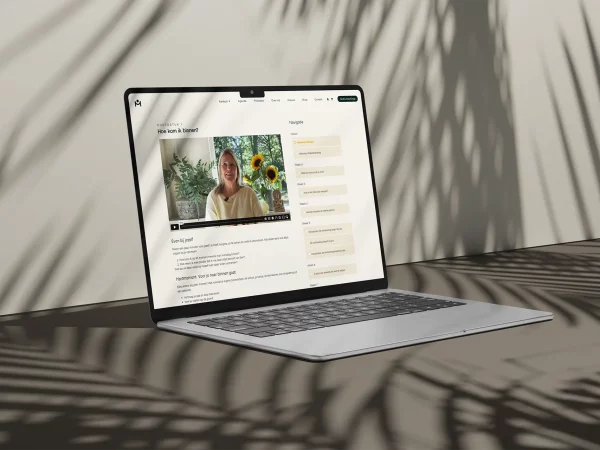 Laptop met de online cursusomgeving van 'Hart voor Jezelf', met hoofdstuk 1 'Hoe kom ik binnen?' en een videoles van Ingrid van Essen van Hartgedragen Onderwijs